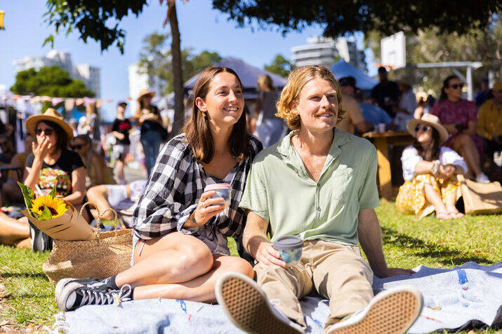 couple enjoying coffee together on a picnic blanket at an outdoor market, a popular choice for relaxed date ideas gold coast