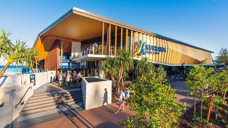 Kurrawa Surf Club near the beachfront with modern architecture and palm-lined walkways — a lively hub steps away from Broadbeach apartments accommodation.